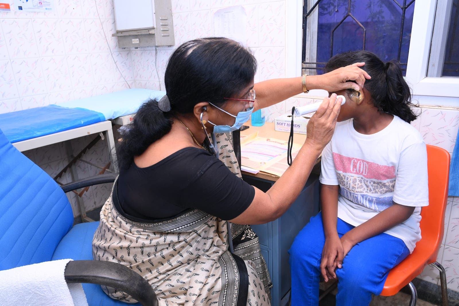 CMCT உடல்நலப் பரிசோதனை முகாமில் ஒரு குழந்தையைப் பரிசோதிக்கும் மருத்துவர்